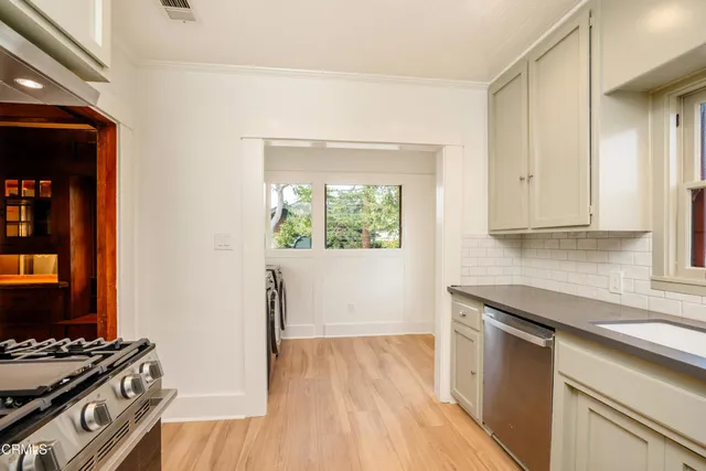 a kitchen with wooden floor and a stove top oven