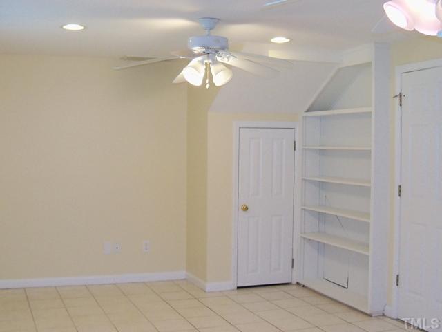 2124 Balboa Road Raleigh, NC 27603 - Photo 6 of 24 Lower level family room (or possible 5th bedroom) with ceramic tile flooring, bookcase, ceiling fans and recessed lighting