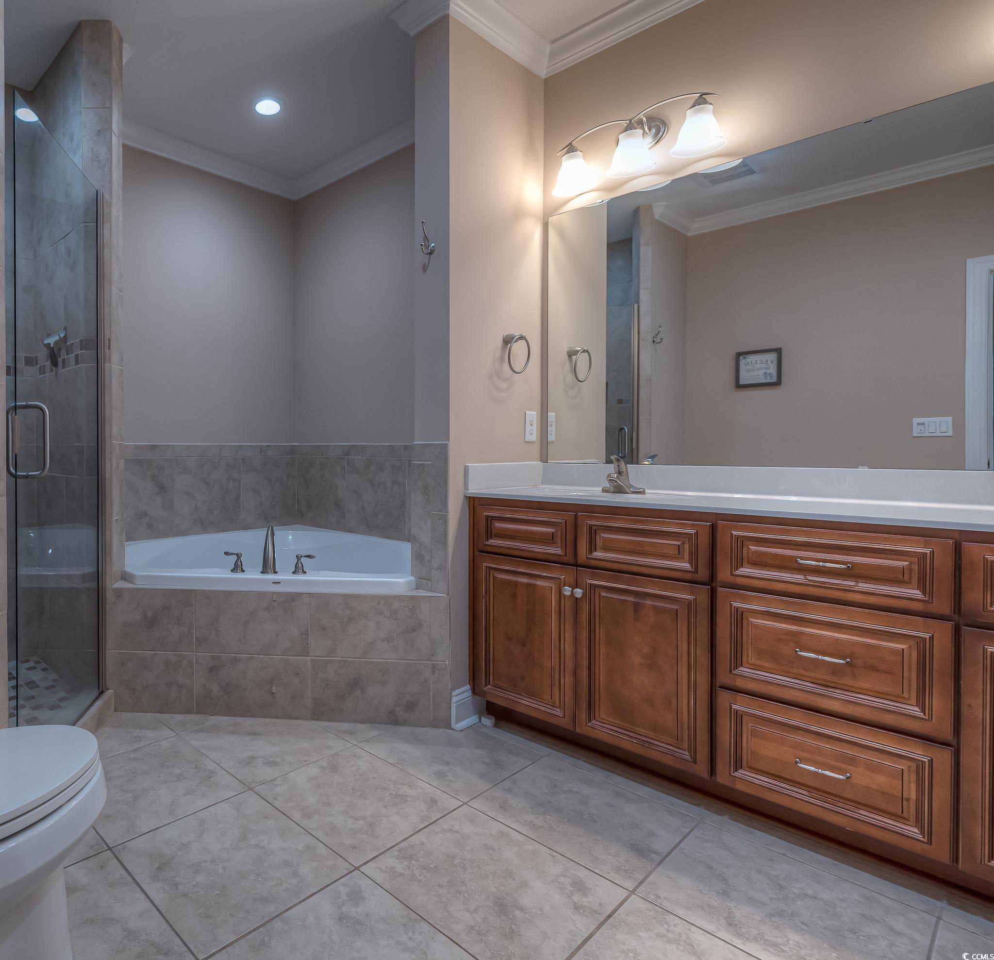 103 Charles Towne Lane Murrells Inlet, SC 29576 - Photo 16 of 23 Full bath featuring ornamental molding, tile patterned flooring, vanity, a garden tub, and a stall shower