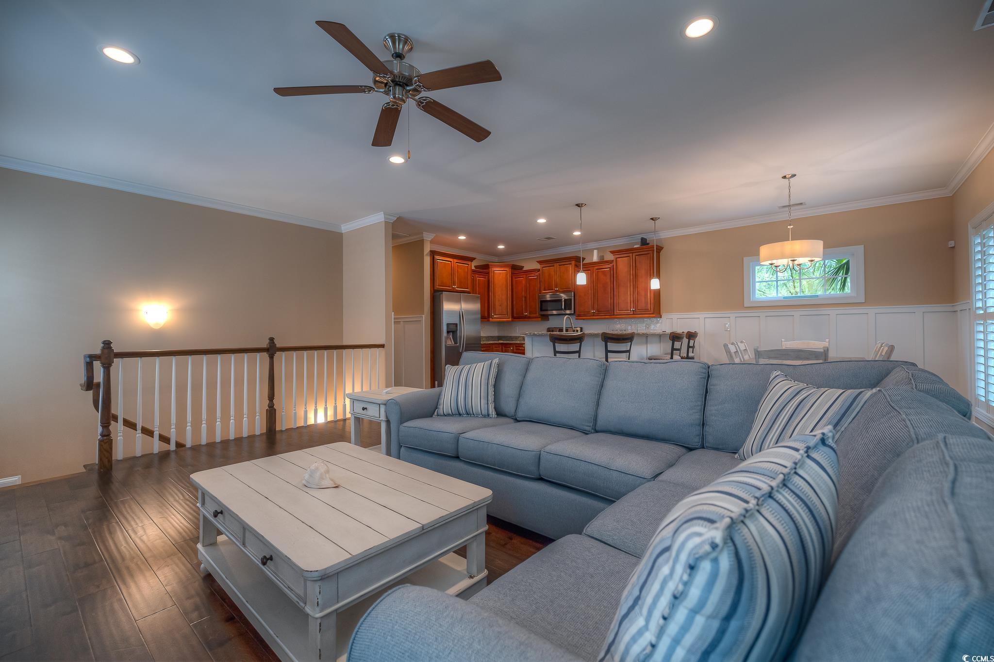 103 Charles Towne Lane Murrells Inlet, SC 29576 - Photo 8 of 23 Living room featuring crown molding, ceiling fan, dark wood-type flooring, wainscoting, and recessed lighting