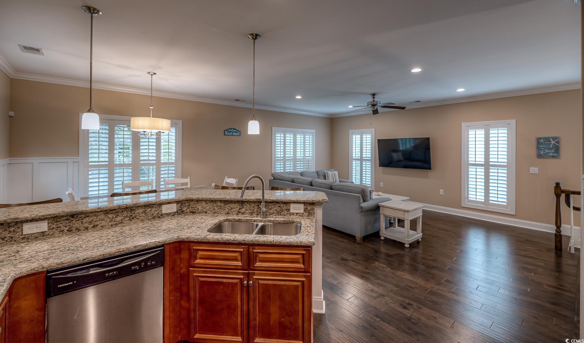 103 Charles Towne Lane Murrells Inlet, SC 29576 - Photo 10 of 23 Kitchen with dishwasher, brown cabinetry, crown molding, light stone countertops, and a ceiling fan