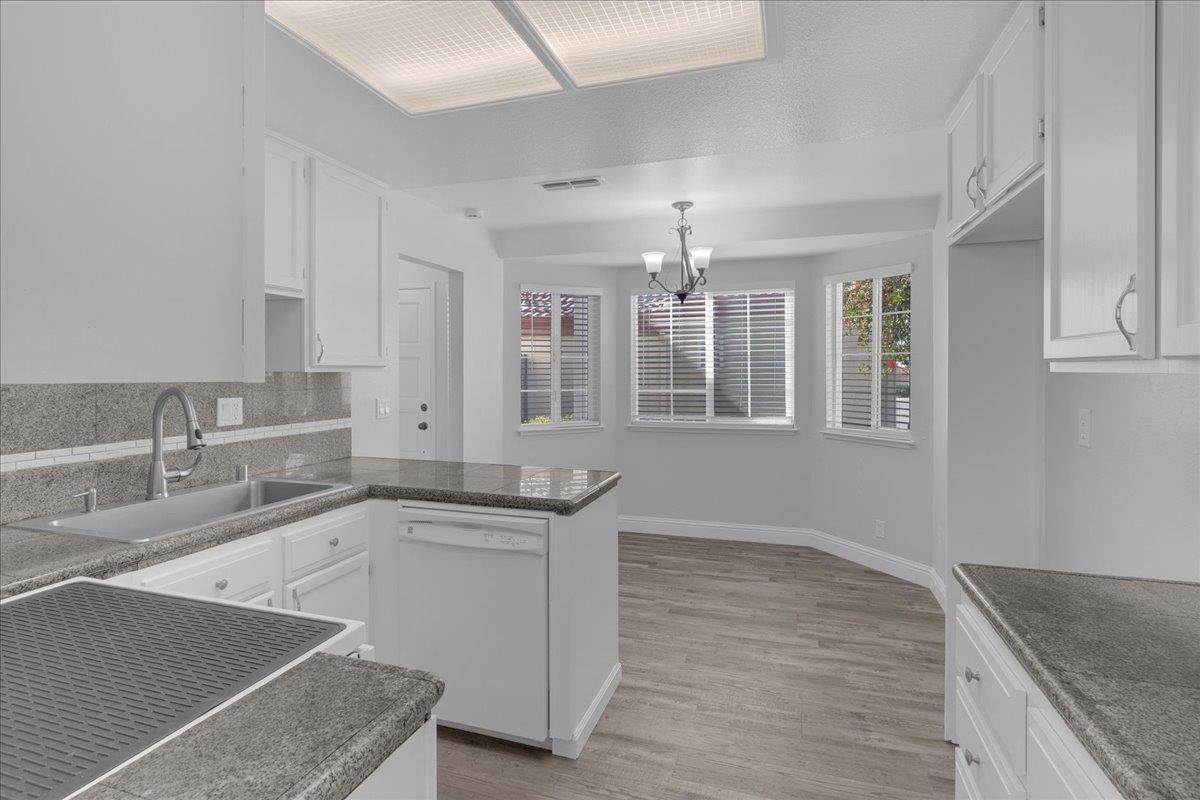 159 Dolphin Circle Marina, CA 93933 - Photo 21 of 31 a large kitchen with granite countertop a sink and dishwasher cabinets with wooden floor