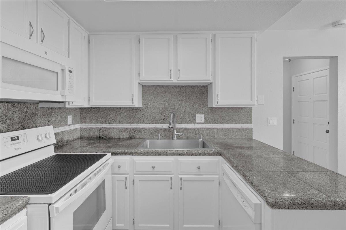 159 Dolphin Circle Marina, CA 93933 - Photo 7 of 31 a kitchen with granite countertop a sink a stove and cabinets