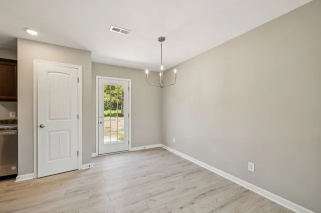 an empty room with wooden floor hallway and hallway