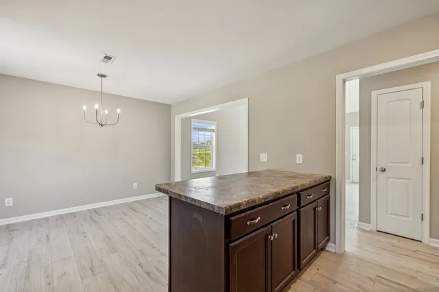 an empty room with wooden floor and window