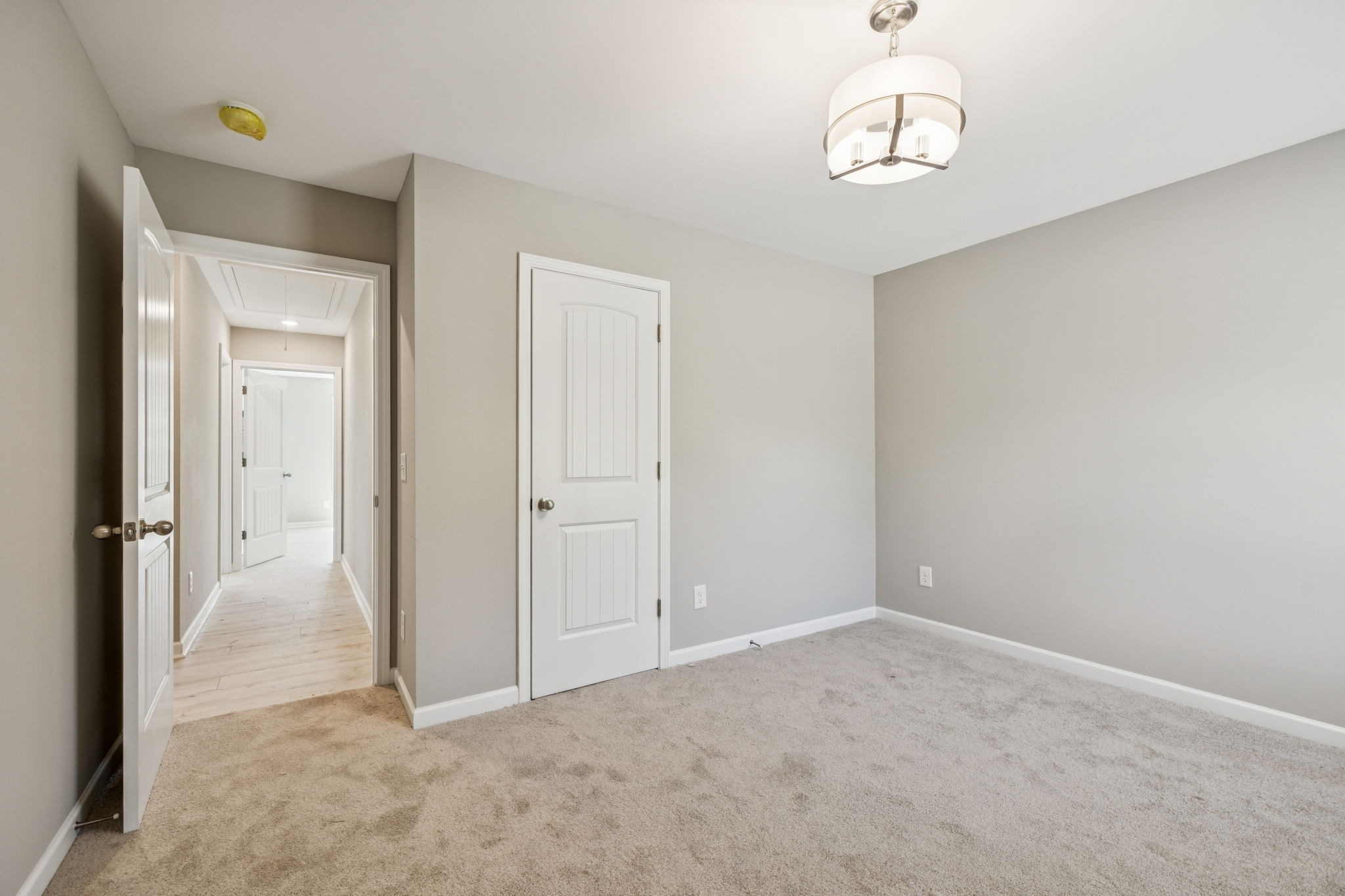 146 Old Brick Church Road Estill Springs, TN 37330 - Photo 27 of 44 an empty room with a chandelier fan and wooden floor