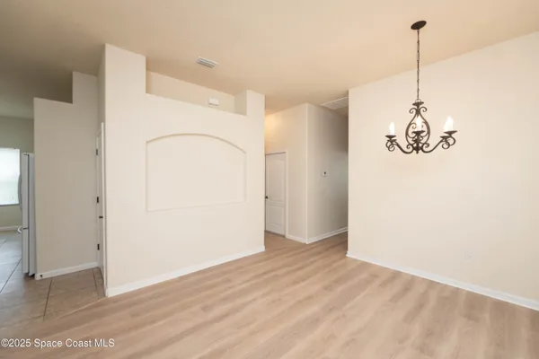 a view of a room with wooden floor and white walls