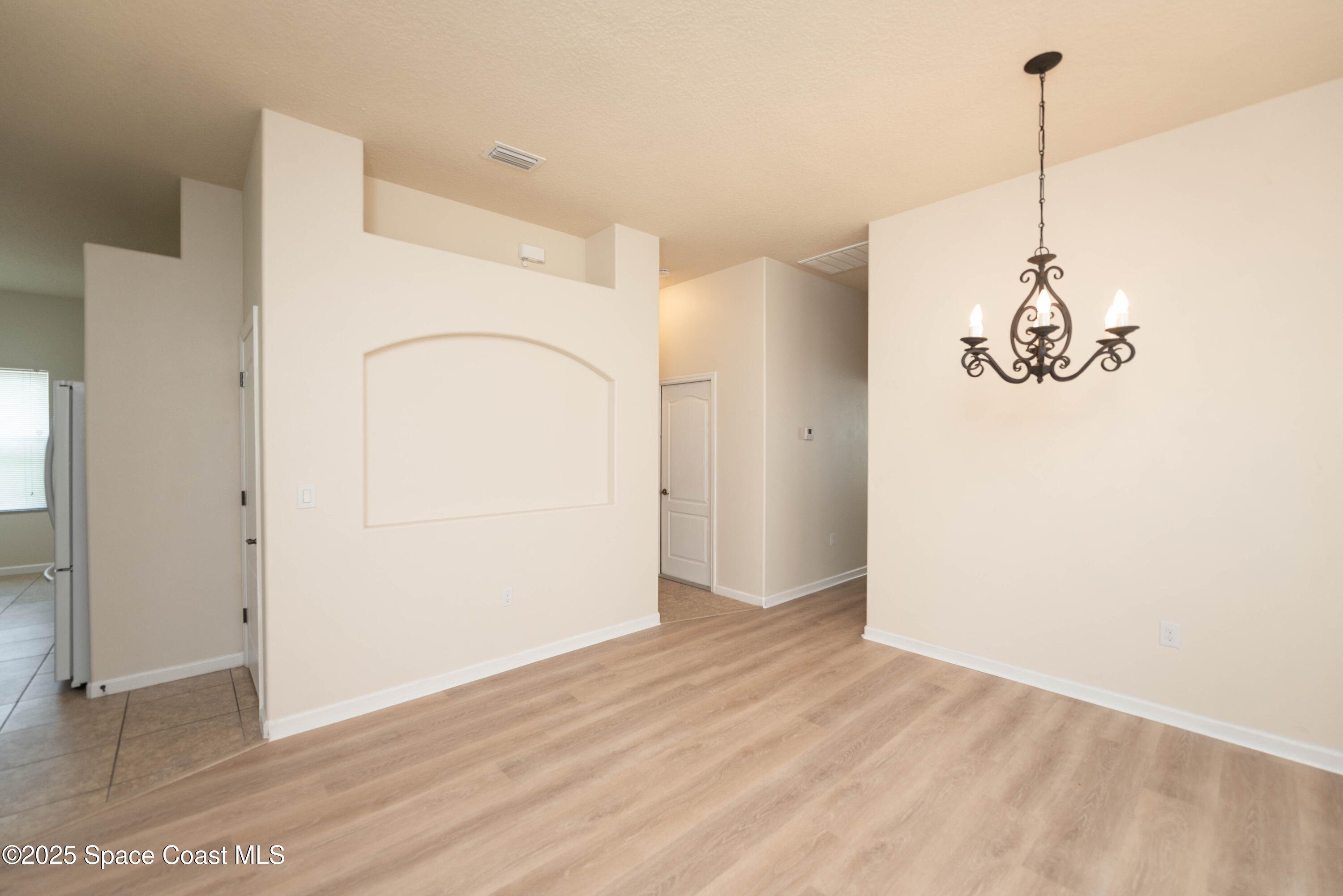 3136 Constellation Drive Melbourne, FL 32940 - Photo 17 of 28 a view of a room with wooden floor and white walls