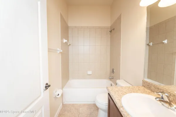 a bathroom with a granite countertop tub sink and mirror