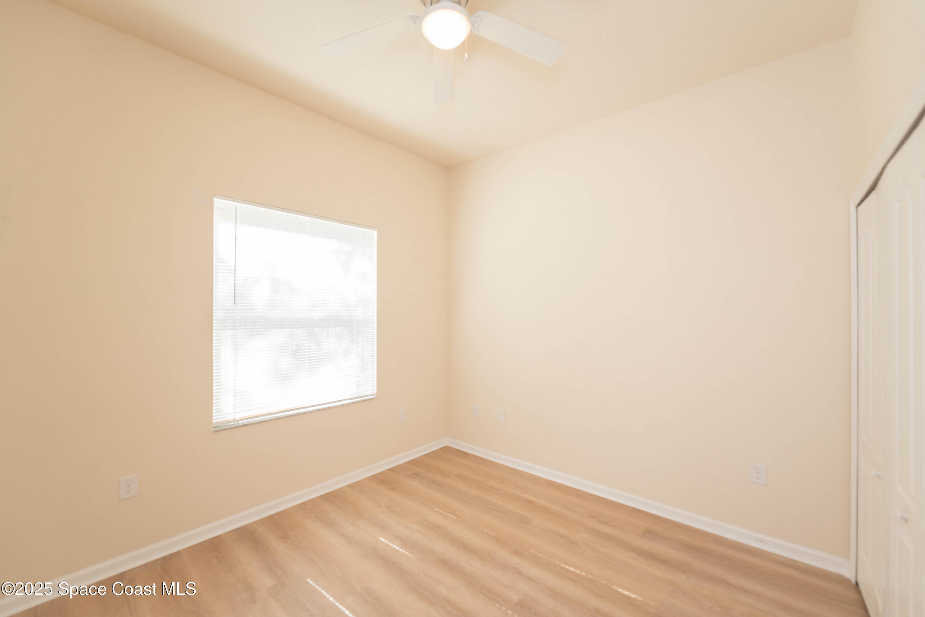 3136 Constellation Drive Melbourne, FL 32940 - Photo 20 of 28 an empty room with wooden floor and windows