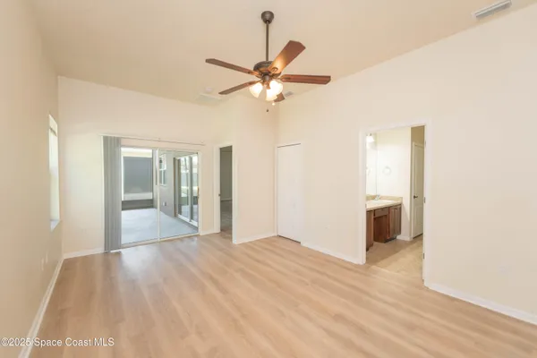 a view of a livingroom with a chandelier fan and a kitchen