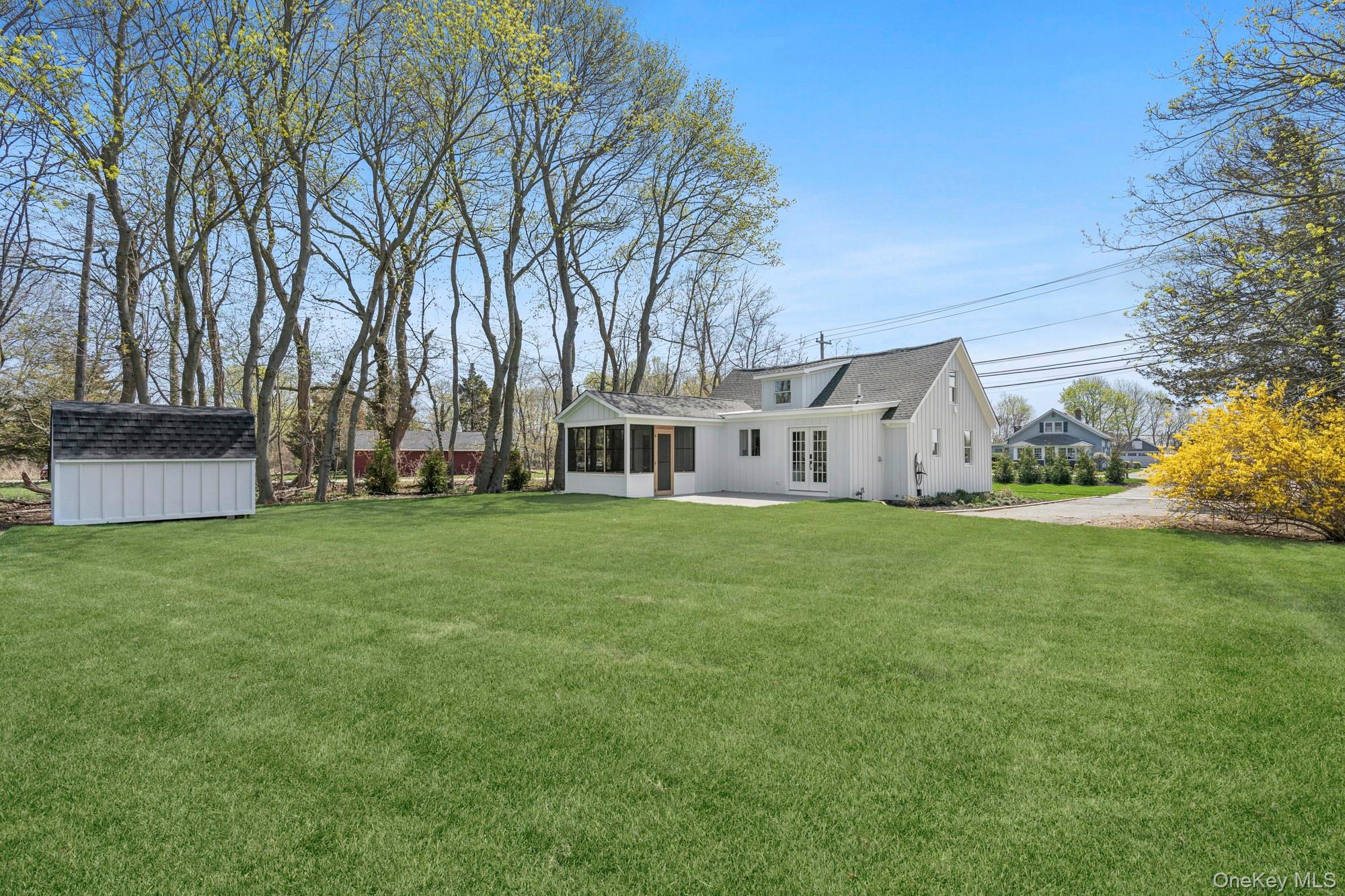 5075 Main Road Laurel, NY 11948 - Photo 17 of 22 a view of a white house that has a tree in the grass