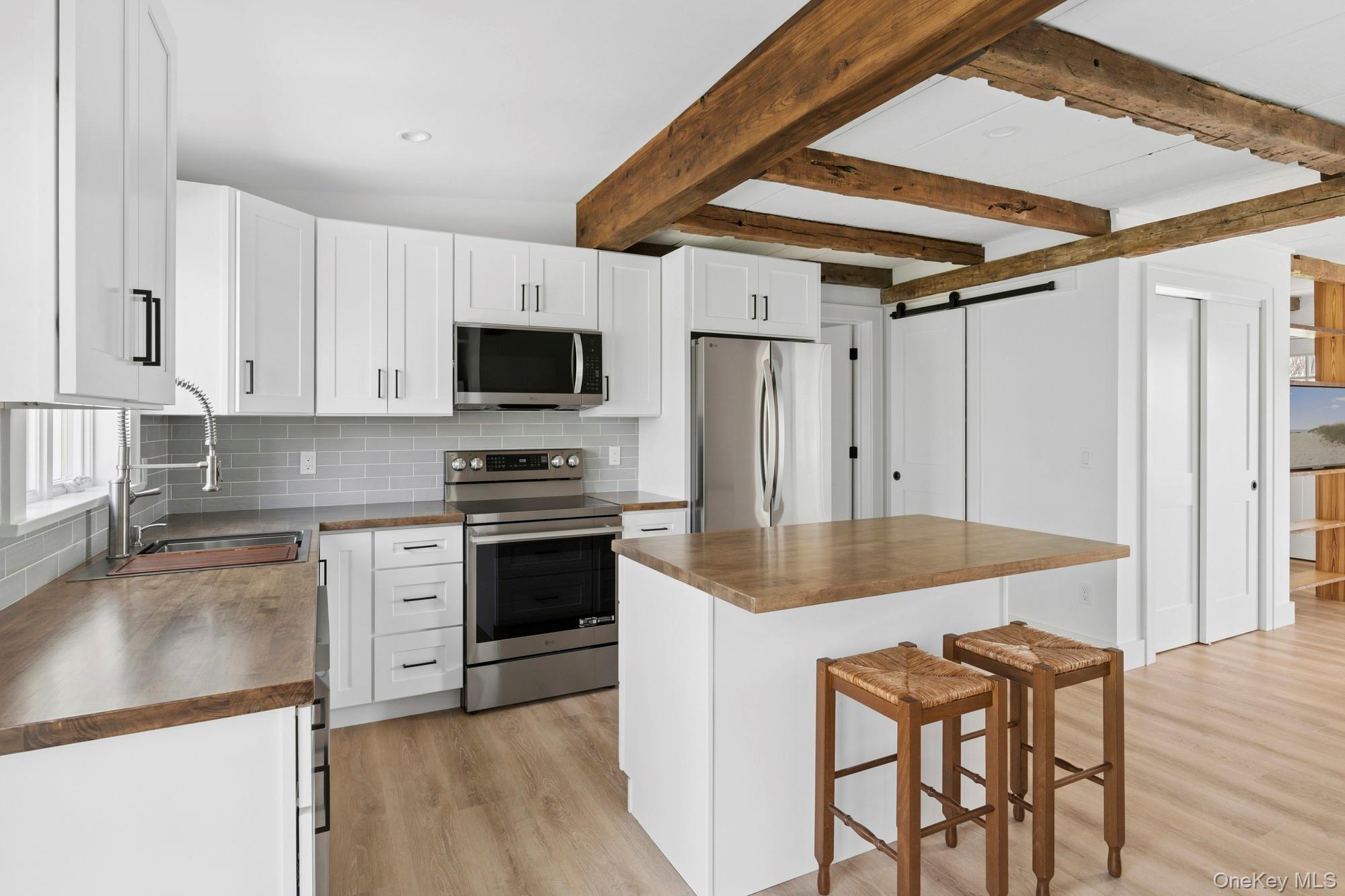 5075 Main Road Laurel, NY 11948 - Photo 9 of 22 a kitchen with granite countertop a sink appliances and cabinets