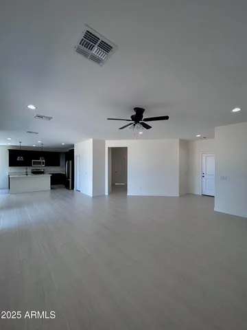 an empty room with windows and fan