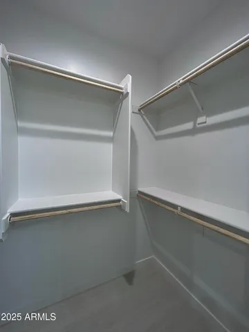 a view of walk in closet with empty racks
