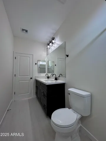 a view of a room with wooden floor and a ceiling fan