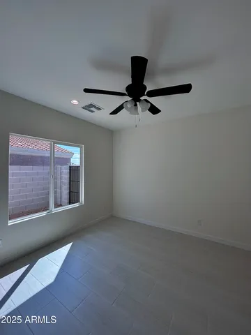an empty room with windows and fan
