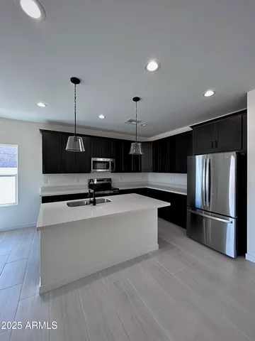 a kitchen with stainless steel appliances granite countertop a refrigerator sink and stove