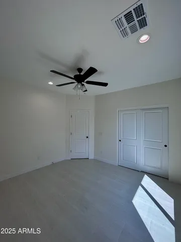 an empty room with a ceiling fan and window