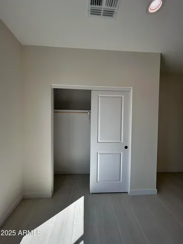 a view of an empty room with window and closet area