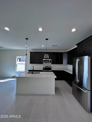 a kitchen with stainless steel appliances kitchen island granite countertop a refrigerator and a stove