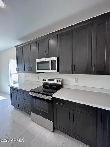a kitchen with a sink a counter space appliances and cabinets