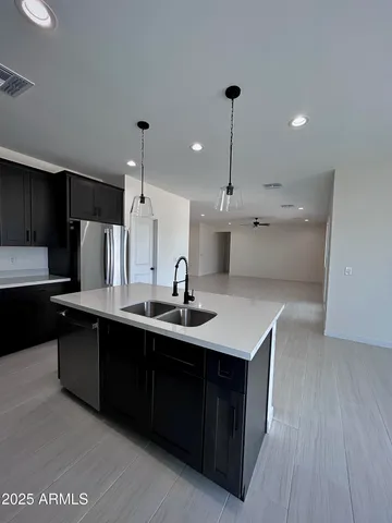 a large kitchen with stainless steel appliances kitchen island a large counter top and a wooden floors