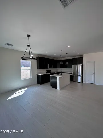 an empty room with wooden floor cabinet and windows