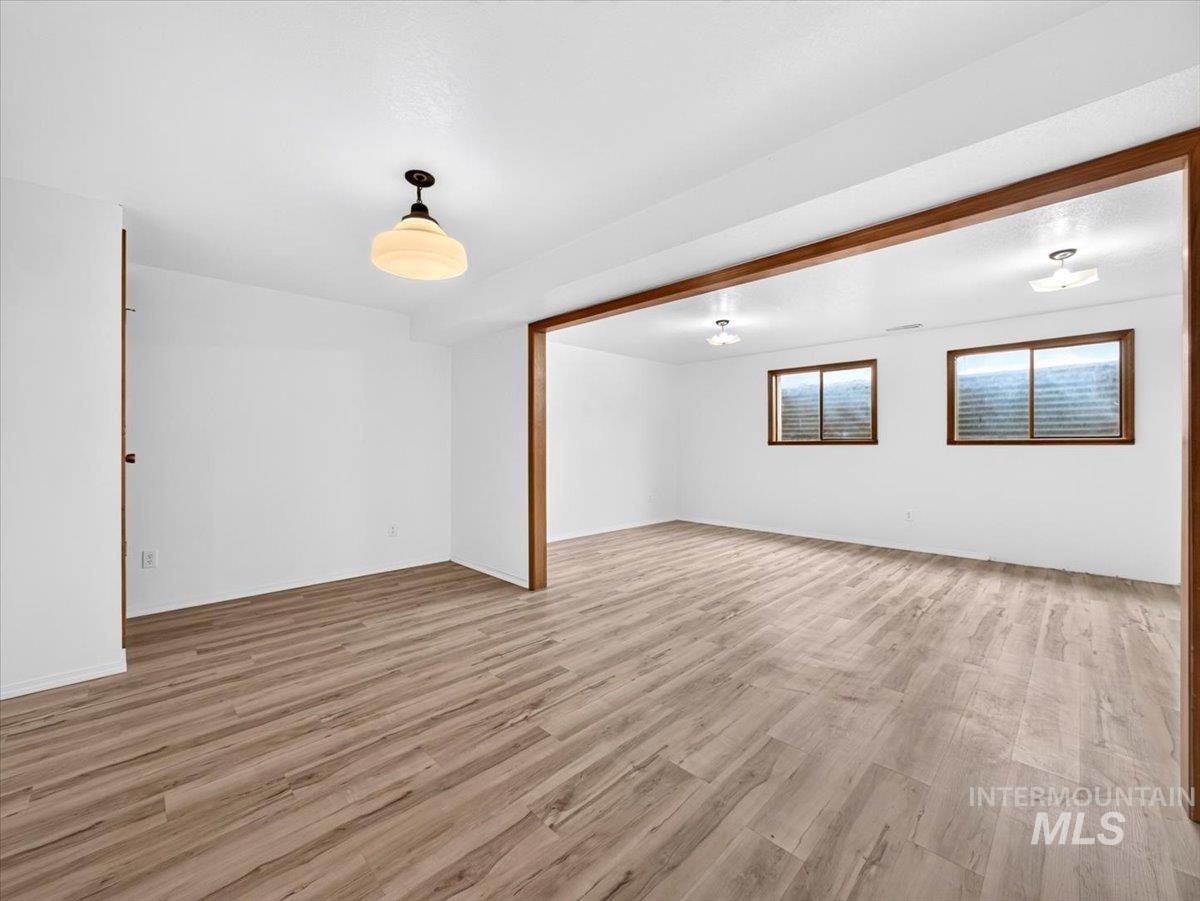 8989 Hillview Road Emmett, ID 83617 - Photo 35 of 50 Spacious room featuring wood-finish flooring, white walls, and a wood-beam entryway