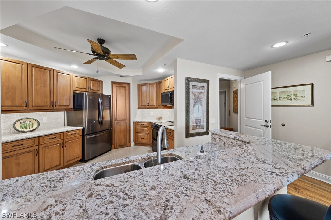 2743 First Street, Unit 1101 Fort Myers, FL 33916 - Photo 10 of 49 a large kitchen with stainless steel appliances granite countertop a sink refrigerator and cabinets