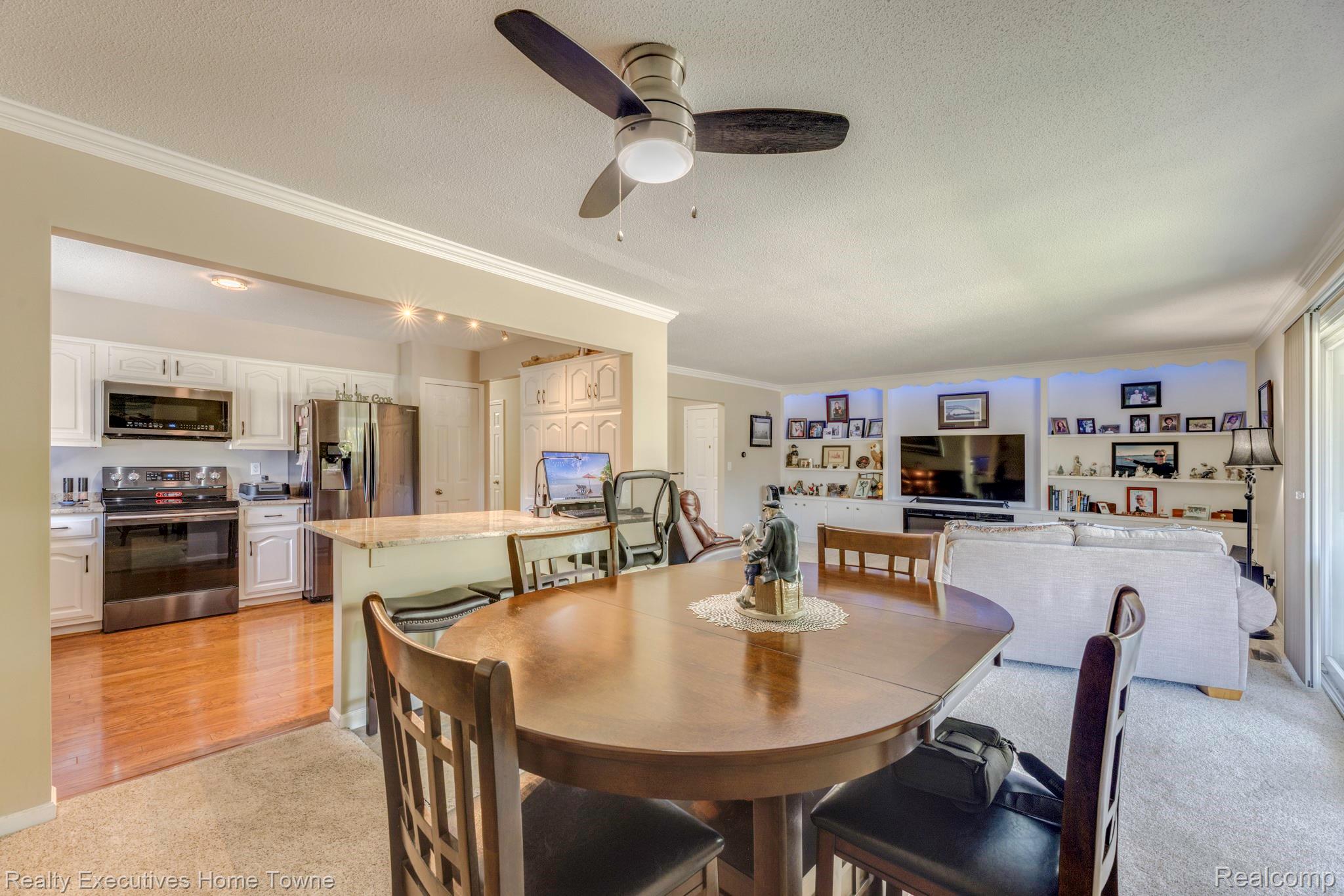 1467 Krafft Road, Unit 8 Port Huron, MI 48060 - Photo 10 of 30 Open-concept living area with a ceiling fan, light-colored carpeting, and crown molding