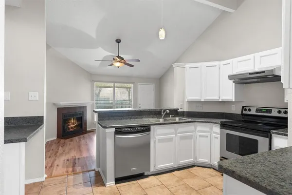 a kitchen with a stove sink and cabinets