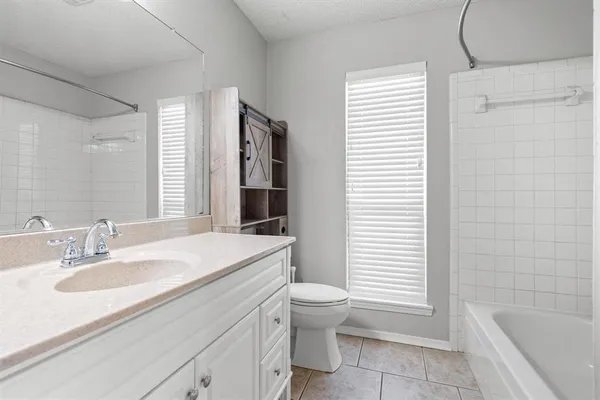 a bathroom with a sink toilet vanity and bathtub