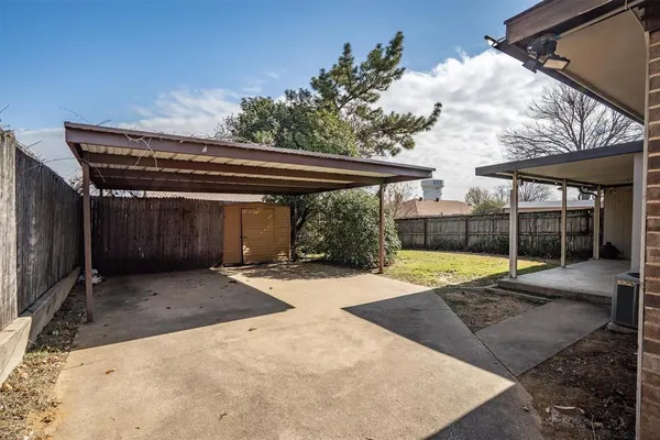 a view of backyard with wheel chair and iron fence