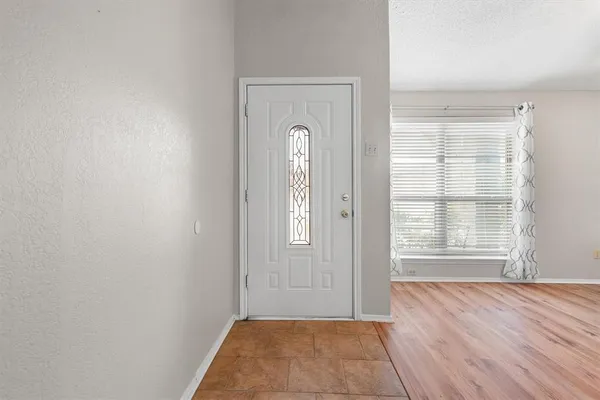 an empty room with wooden floor and a window