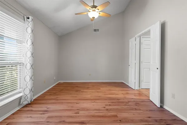 a view of a room with wooden floor and a ceiling fan