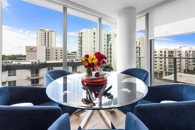 a dining room with furniture and a large window
