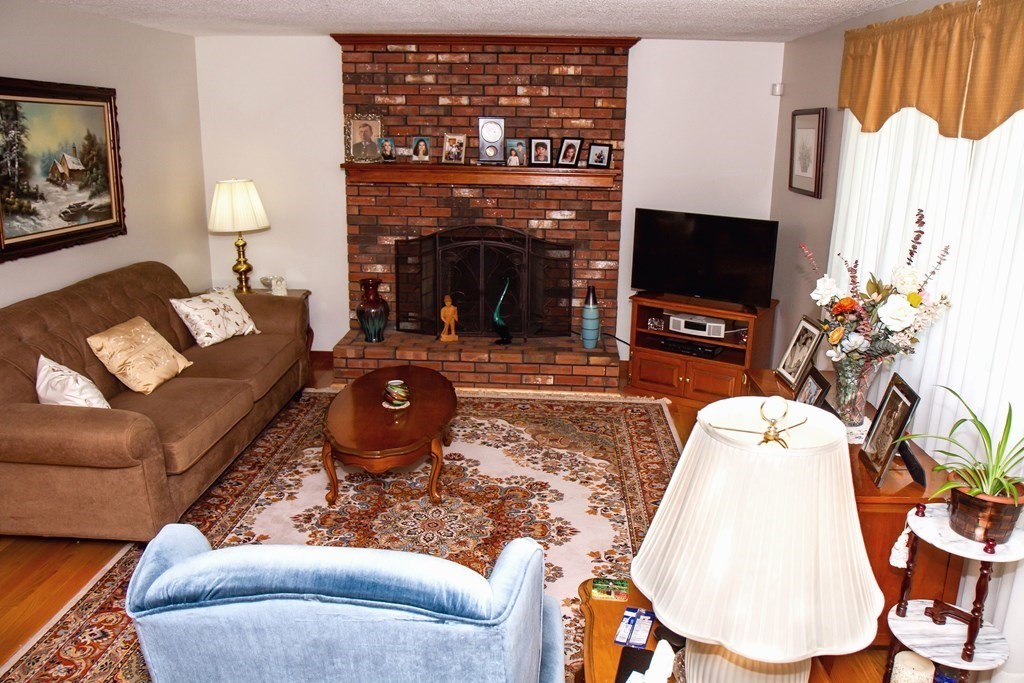 106 Lawrence Road Chicopee, MA 01013 - Photo 14 of 39 a living room with furniture a flat screen tv and a fireplace