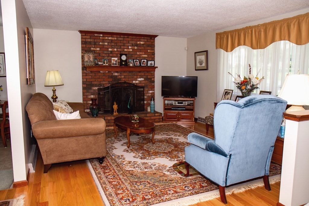 106 Lawrence Road Chicopee, MA 01013 - Photo 15 of 39 a living room with furniture a fireplace and a flat screen tv