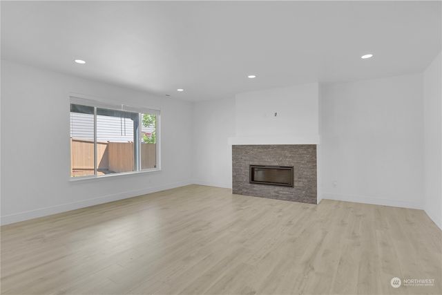 an empty room with windows and fireplace