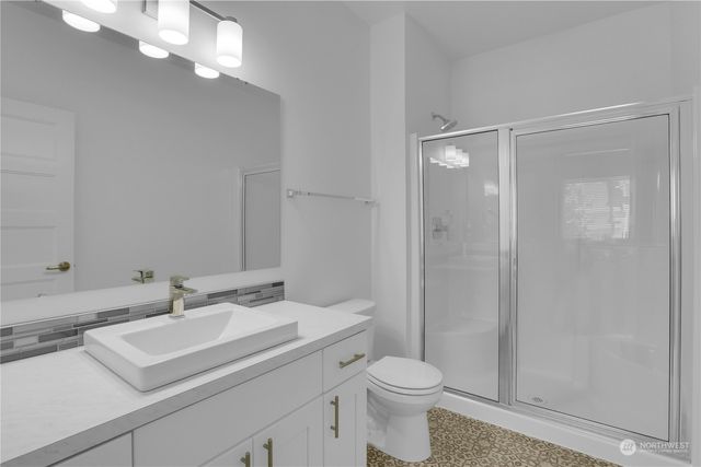 a bathroom with a sink a toilet and shower