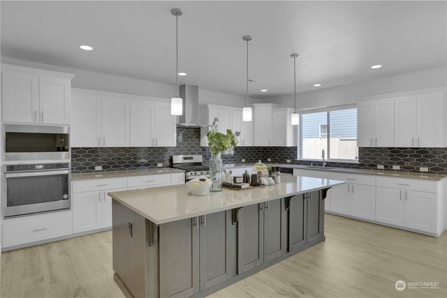 a kitchen with kitchen island a sink stainless steel appliances and cabinets