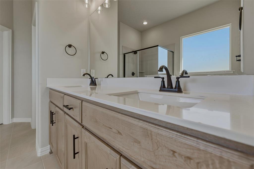 153 Big Sky Road Decatur, TX 76234 - Photo 29 of 38 Dual vanity with light wood-finish cabinetry, white countertops, and matte black fixtures
