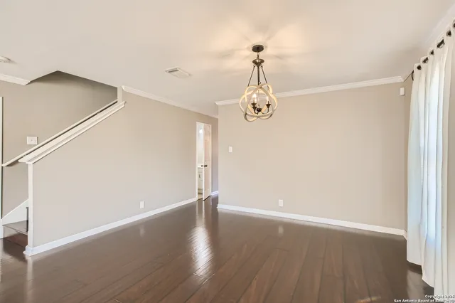 a view of a room with wooden floor and white walls