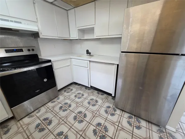 a kitchen with a sink and a refrigerator