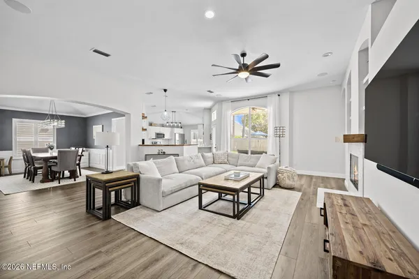 a living room with furniture a flat screen tv and a table