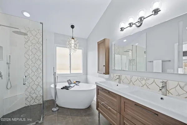 a bathroom with a bathtub shower sink and mirror