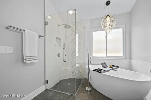 a bathroom with a tub a sink and mirror
