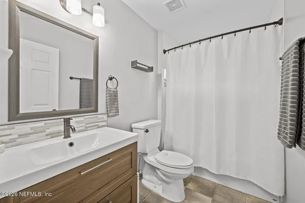 a bathroom with a sink a toilet and shower curtain