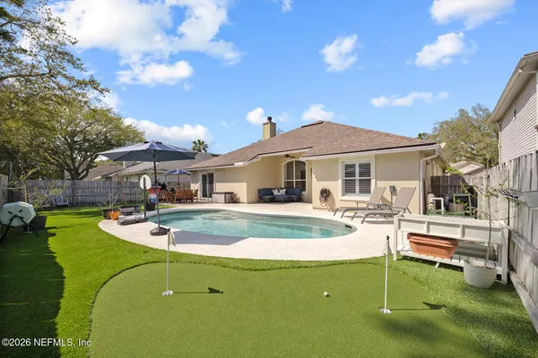 a view of house with swimming pool outdoor seating